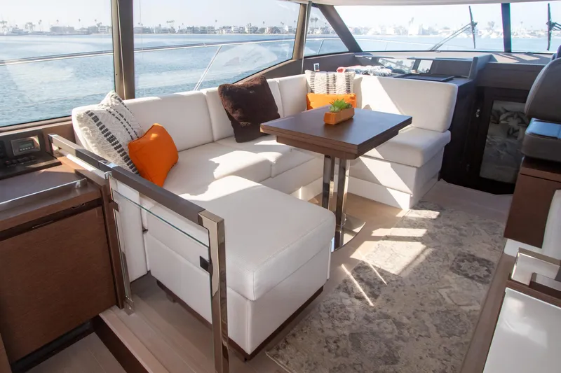 Fantasea Yacht Photos Pics Luxurious interior of 2020 Prestige 460 Fly yacht with white seating and wooden table.