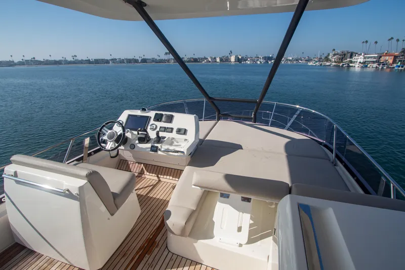 Fantasea Yacht Photos Pics Prestige 460 Fly 2020 yacht flybridge with helm station and seating area on calm waters.