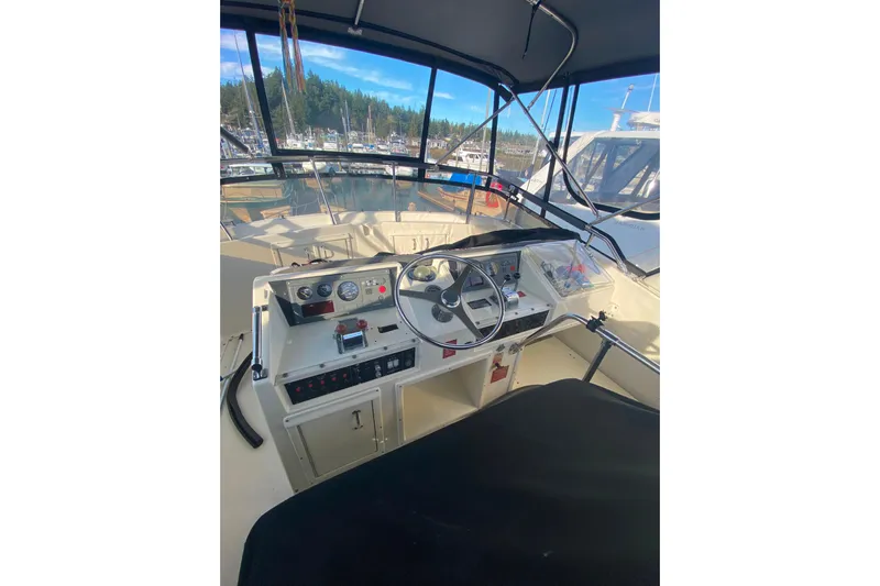  Yacht Photos Pics 1988 Hatteras 40 Double Cabin helm with steering wheel and control panel, docked in marina.