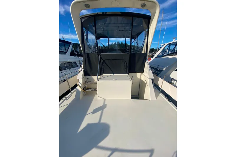  Yacht Photos Pics 1988 Hatteras 40 Double Cabin yacht with spacious deck and canopy, docked at marina.