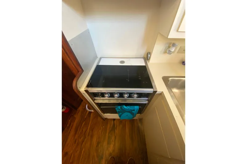 Yacht Photos Pics Compact kitchen area in a 1988 Hatteras 40 Double Cabin yacht with stove and sink.