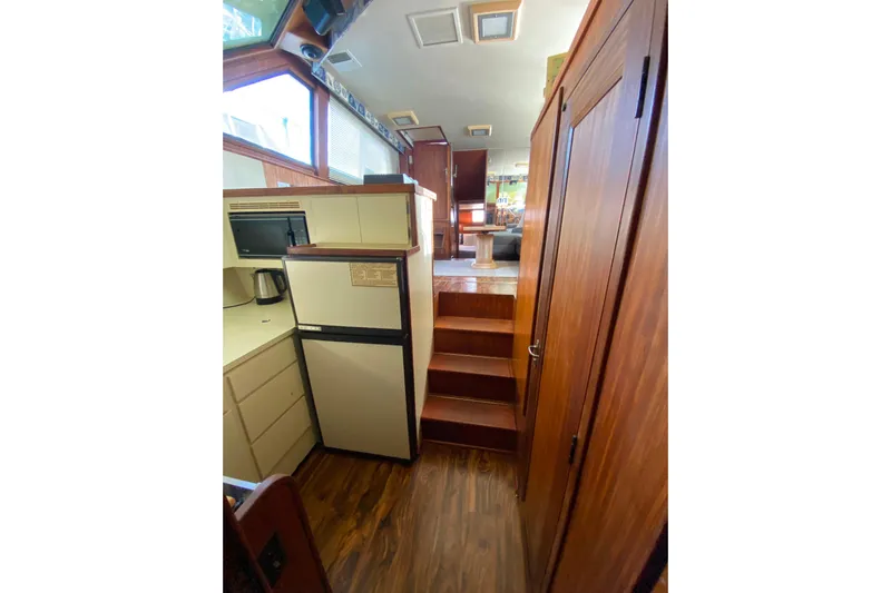  Yacht Photos Pics Interior of 1988 Hatteras 40 Double Cabin yacht with wood finishes and compact kitchen.