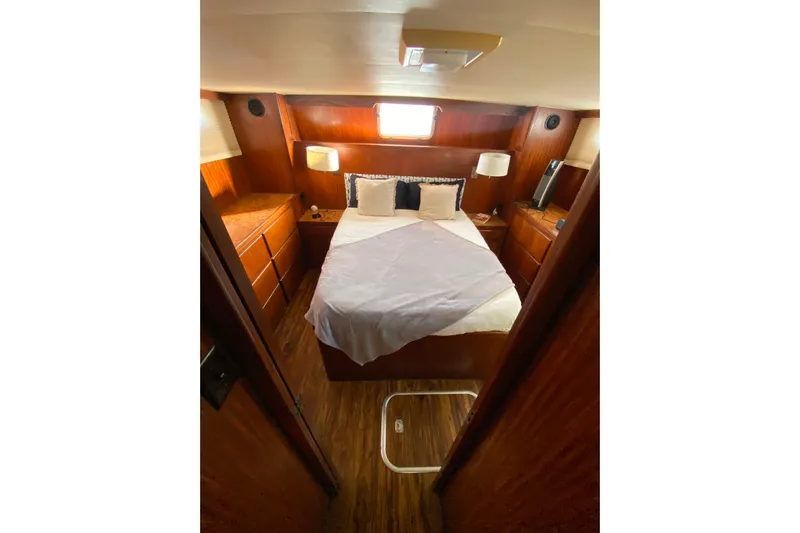  Yacht Photos Pics Cozy cabin interior of 1988 Hatteras 40 Double Cabin yacht with bed and wooden furnishings.