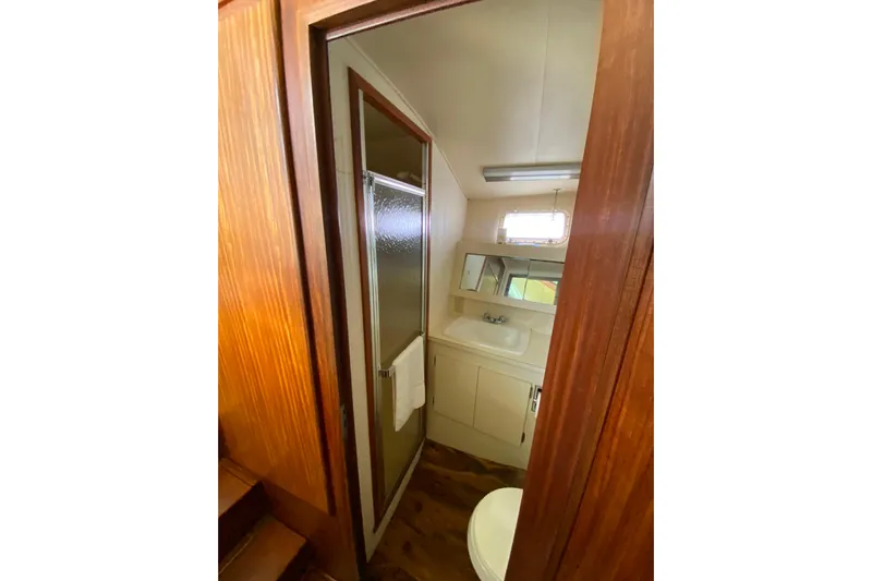  Yacht Photos Pics 1988 Hatteras 40 Double Cabin bathroom with shower, sink, and wooden accents.