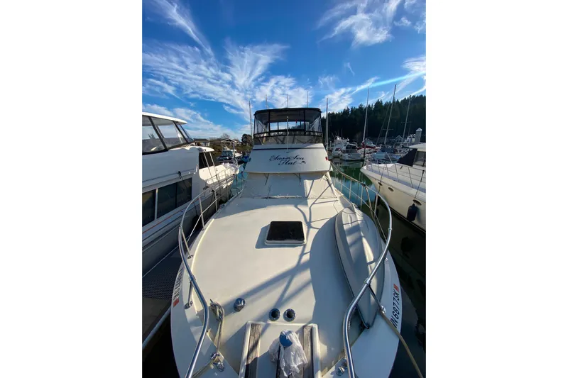  Yacht Photos Pics 1988 Hatteras 40 Double Cabin yacht docked under a vibrant blue sky.