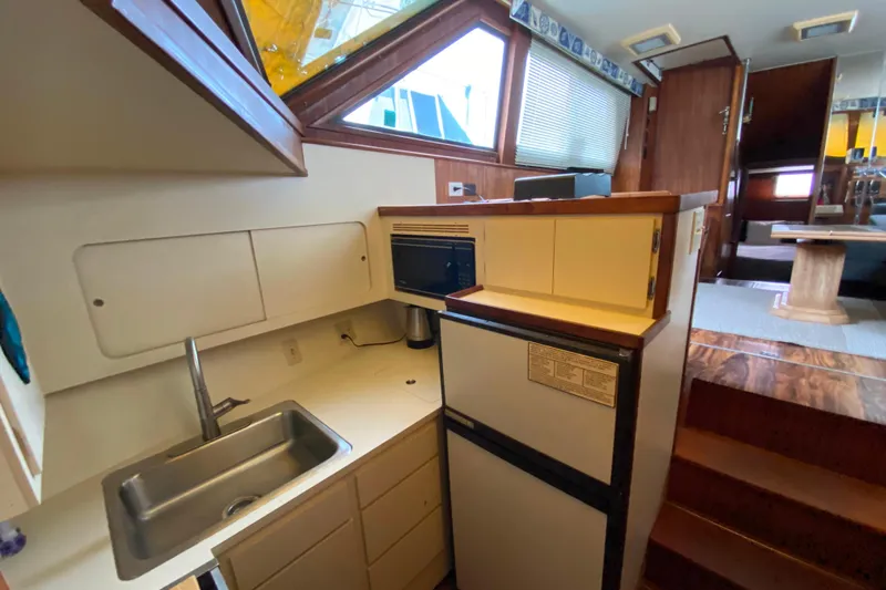  Yacht Photos Pics 1988 Hatteras 40 Double Cabin yacht interior with kitchenette, sink, and compact appliances.