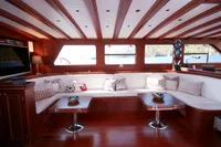 Luxurious interior of a 2020 custom schooner with elegant wood finish and plush seating.