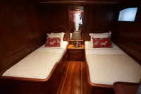 Luxurious wooden cabin interior with twin beds on a 2020 custom schooner.