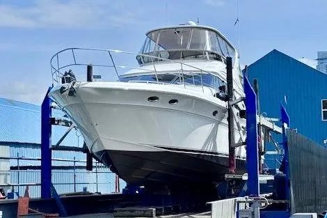 Hustler I Yacht Photos Pics 2000 Sea Ray 560 Sedan Bridge yacht on a lift at a marina.
