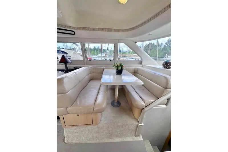 Hustler I Yacht Photos Pics Luxurious interior of 2000 Sea Ray 560 Sedan Bridge yacht with plush seating and table.