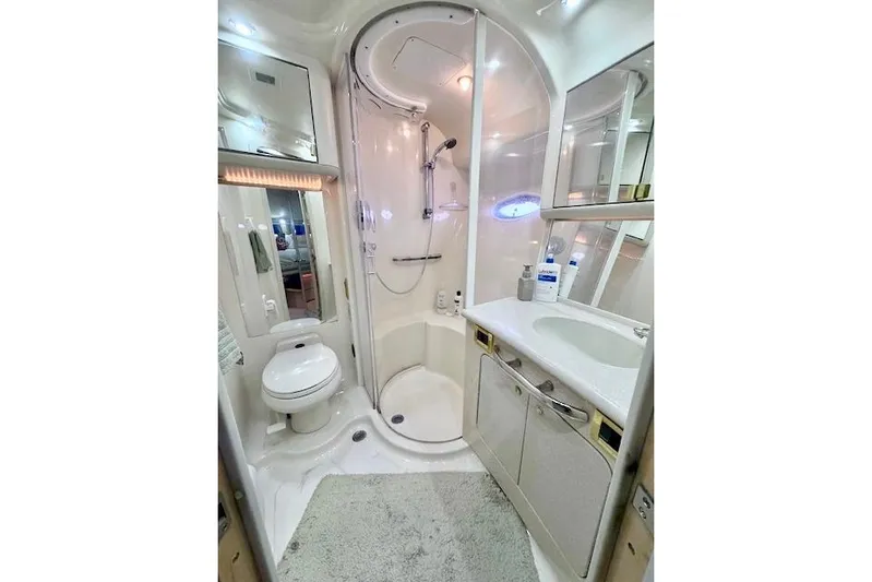 Hustler I Yacht Photos Pics Luxurious bathroom in 2000 Sea Ray 560 Sedan Bridge yacht, featuring shower, toilet, and vanity.