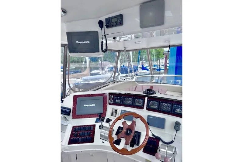 Hustler I Yacht Photos Pics 2000 Sea Ray 560 Sedan Bridge helm with Raymarine electronics and wooden steering wheel.