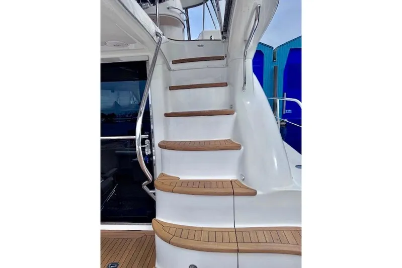 Hustler I Yacht Photos Pics Staircase on 2000 Sea Ray 560 Sedan Bridge yacht with wooden steps and metal railing.