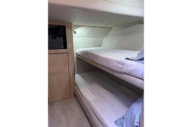 Hustler I Yacht Photos Pics Interior of 2000 Sea Ray 560 Sedan Bridge with bunk beds and storage cabinet.