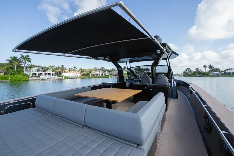  Yacht Photos Pics 2025 Pardo Yachts 50 with spacious deck, seating, and canopy on a serene waterfront.