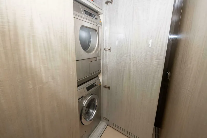 Satisfaction Yacht Photos Pics Laundry area with stacked washer and dryer in 2017 Azimut 84 Flybridge yacht.
