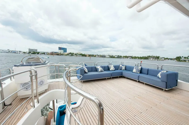 Satisfaction Yacht Photos Pics Azimut 84 Flybridge 2017 yacht deck with blue seating, overlooking scenic waterfront.