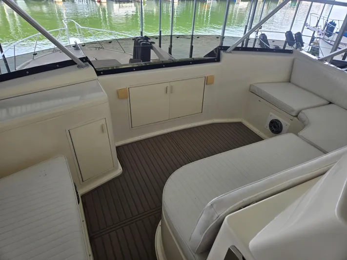 Lay A Wake Yacht Photos Pics 1990 Viking 53 Convertible yacht interior with cushioned seating and wooden flooring.