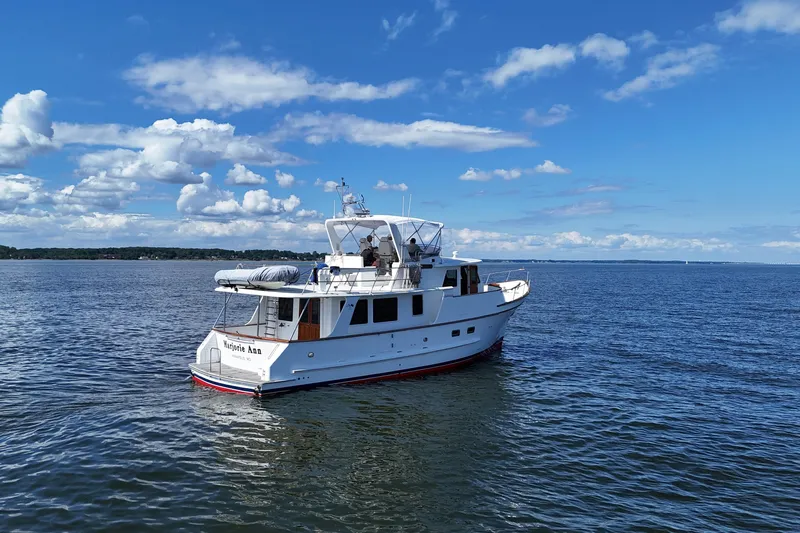 Marjorie Ann Yacht Photos Pics 2006 DeFever 52 Euro yacht cruising on a calm, scenic waterway under a clear blue sky.