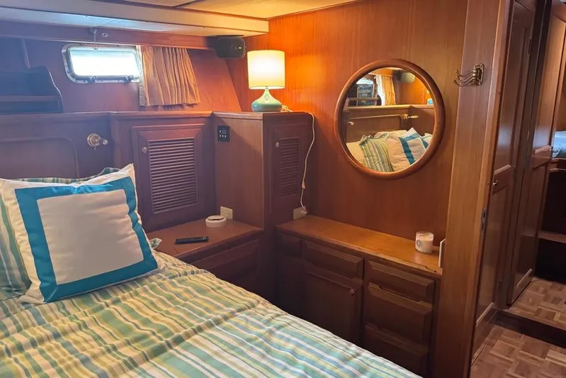 Marjorie Ann Yacht Photos Pics Cozy cabin interior of 2006 DeFever 52 Euro yacht with bed, mirror, and lamp.