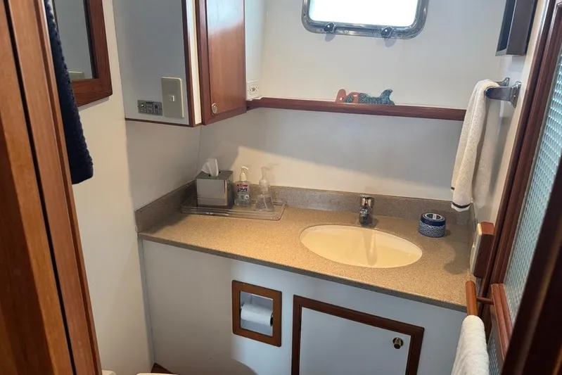 Marjorie Ann Yacht Photos Pics Bathroom interior of 2006 DeFever 52 Euro yacht with sink and wooden accents.