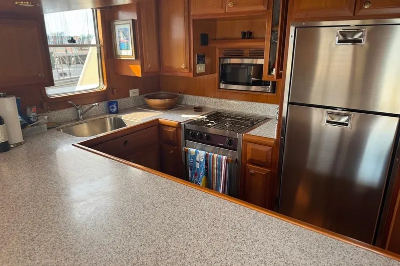 Marjorie Ann Yacht Photos Pics Kitchen interior of 2006 DeFever 52 Euro yacht with modern appliances and wood cabinetry.