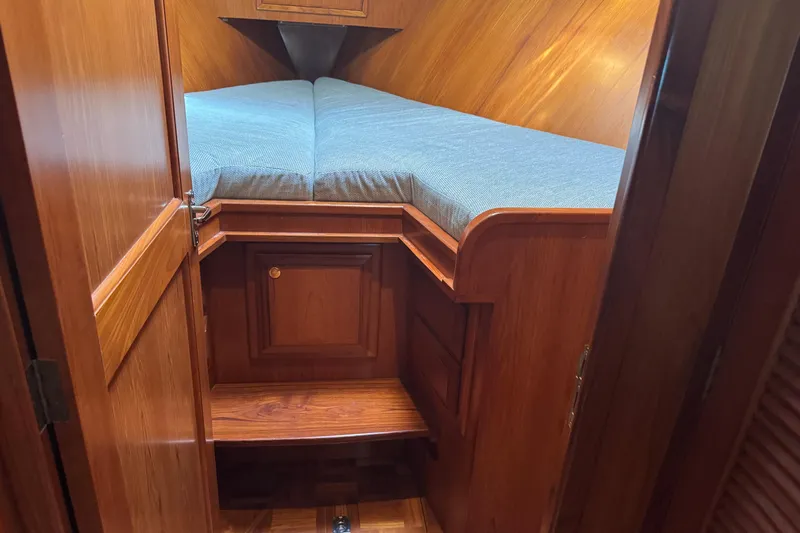 Marjorie Ann Yacht Photos Pics Cozy cabin interior of 2006 DeFever 52 Euro yacht with wooden finish and blue bedding.