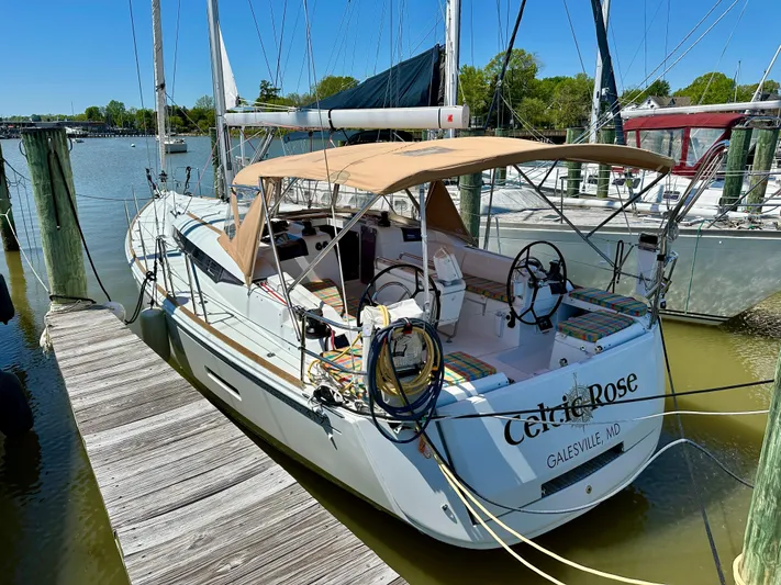 Celtic Rose Yacht Photos Pics 2018 Jeanneau Sun Odyssey 419 sailboat docked, featuring a tan canopy and dual steering wheels.