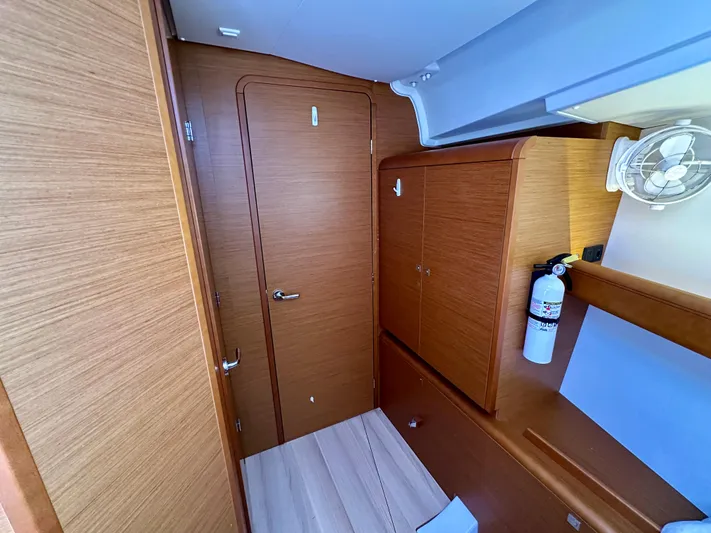 Celtic Rose Yacht Photos Pics Interior of 2018 Jeanneau Sun Odyssey 419 yacht, featuring wooden cabinetry and a fire extinguisher.