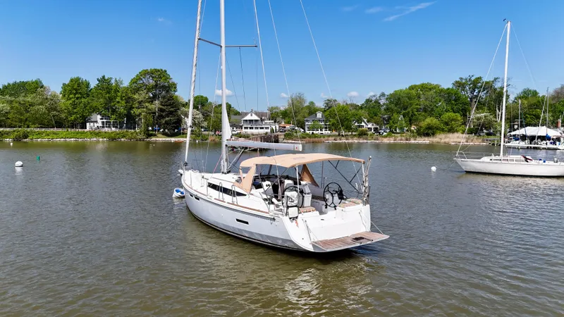 Celtic Rose Yacht Photos Pics 2018 Jeanneau Sun Odyssey 419 sailboat on calm water, surrounded by lush greenery.