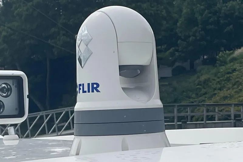  Yacht Photos Pics FLIR camera on 2023 Pursuit OS 445 Offshore boat, surrounded by greenery.