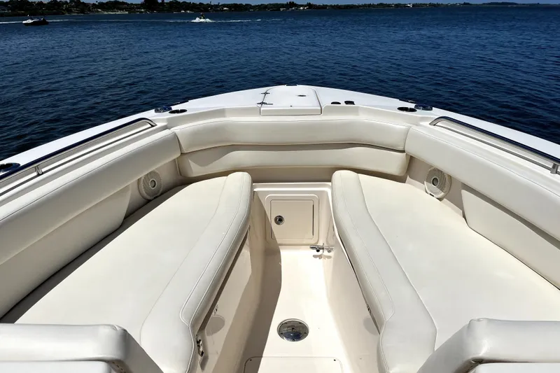 Liquid Carr-ma Yacht Photos Pics 2017 Grady-White Freedom 307 boat interior with white seating, on calm blue water.