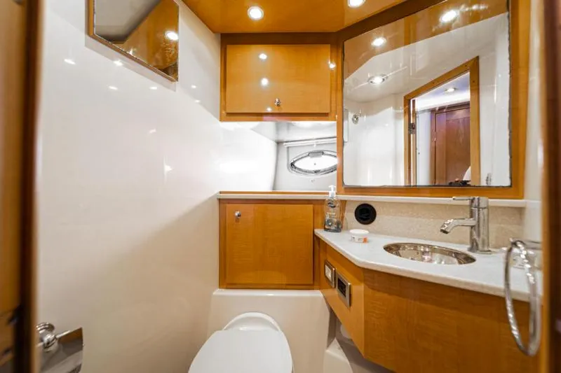 Pura Vida Yacht Photos Pics Luxurious 2011 Four Winns 475 yacht bathroom with modern fixtures and wooden cabinetry.