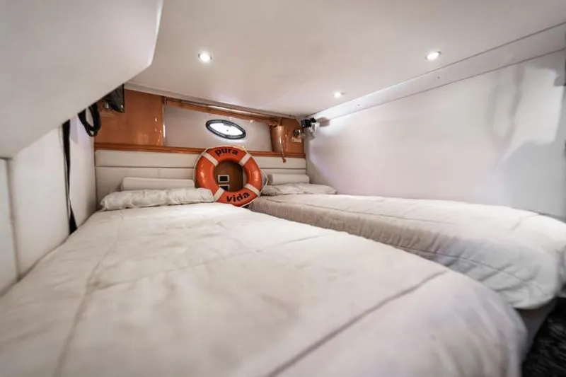 Pura Vida Yacht Photos Pics Interior cabin of 2011 Four Winns 475 yacht with twin beds and a life preserver.