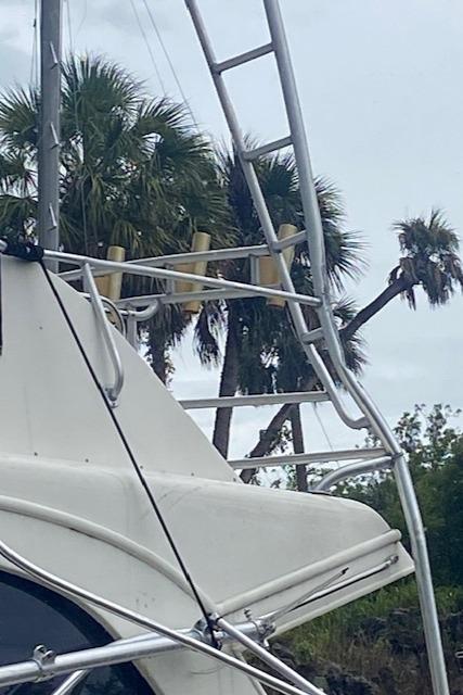 1984 Post 43 Sport Fisherman boat with metal ladder, palm trees in background.