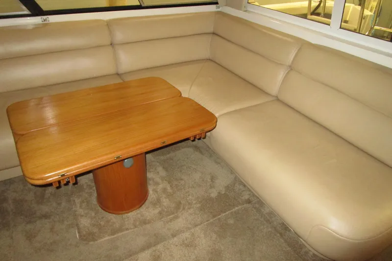 Yeah Yacht Photos Pics Luxurious beige seating and wooden table inside 1999 Bayliner 4788 Pilot House Motoryacht.