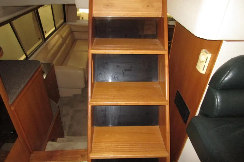 Yeah Yacht Photos Pics Interior of 1999 Bayliner 4788 Pilot House Motoryacht with wooden stairs and seating area.
