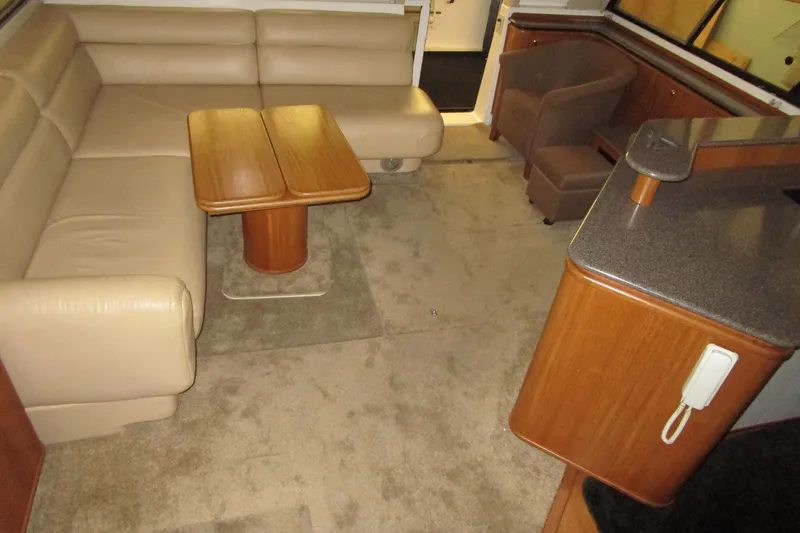 Yeah Yacht Photos Pics Interior of 1999 Bayliner 4788 Pilot House Motoryacht with beige seating and wooden accents.