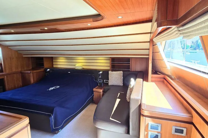 M/y Bleu Blanc Yacht Photos Pics Luxurious bedroom interior of 2009 Ferretti Custom Line 97 yacht with wood paneling.