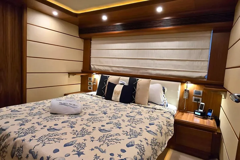 M/y Bleu Blanc Yacht Photos Pics Luxurious bedroom interior on a 2009 Ferretti Custom Line 97 yacht, featuring elegant bedding and wood accents.
