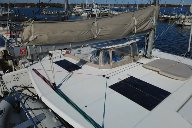About Time Yacht Photos Pics 2021 Lagoon 42 catamaran docked at marina, featuring solar panels and beige sail cover.
