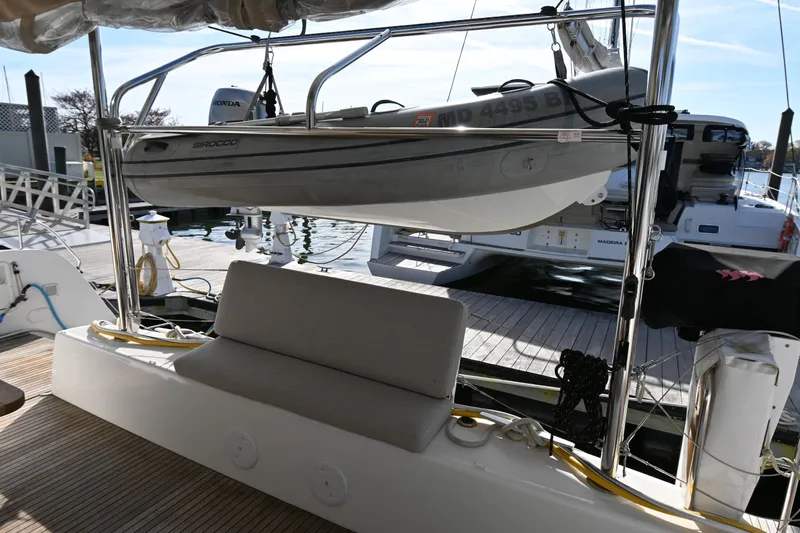 About Time Yacht Photos Pics Lagoon 42 catamaran (2021) with a mounted dinghy at a marina dock.