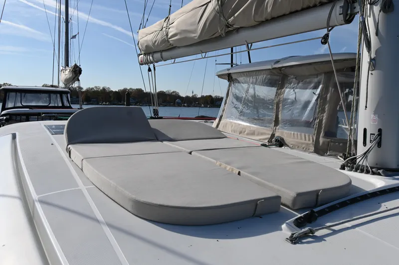 About Time Yacht Photos Pics 2021 Lagoon 42 catamaran with spacious deck and comfortable seating, docked by the water.