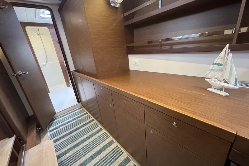 About Time Yacht Photos Pics Interior of 2021 Lagoon 42 yacht with wooden cabinetry and striped rug.