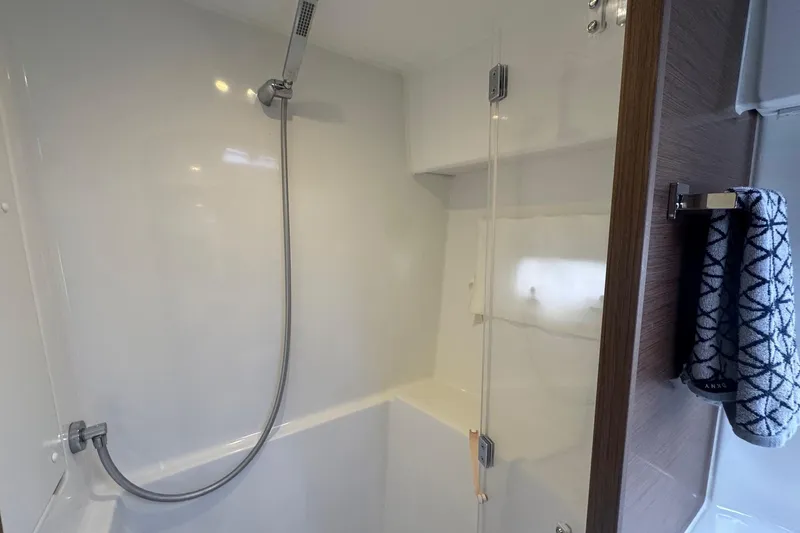 About Time Yacht Photos Pics Modern shower area in a 2021 Lagoon 42 yacht, featuring sleek fixtures and a towel rack.