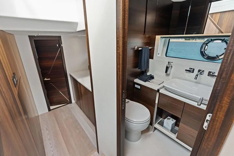  Yacht Photos Pics Luxurious bathroom interior of 2022 Sunseeker 65 Sport Yacht with modern fixtures and wood accents.