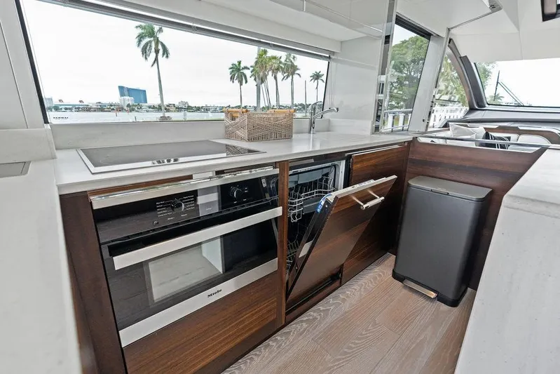  Yacht Photos Pics Modern kitchen interior of 2022 Sunseeker 65 Sport Yacht with appliances and scenic window view.