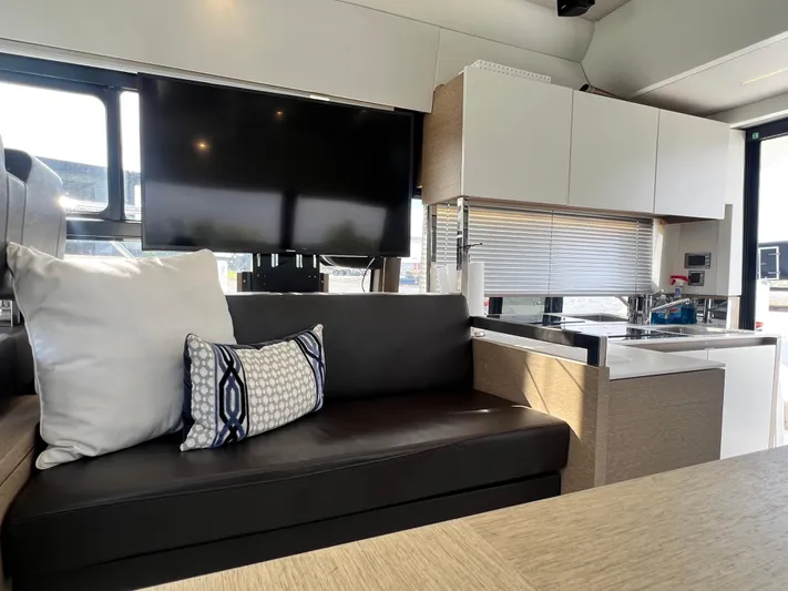  Yacht Photos Pics Modern interior of 2018 Prestige 460 yacht with sofa, TV, and kitchenette.