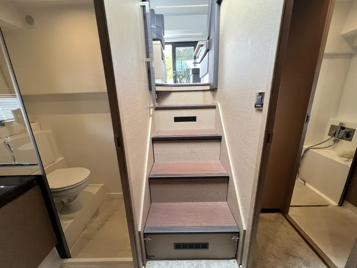  Yacht Photos Pics Staircase inside 2018 Prestige 460 yacht, leading to upper deck, with adjacent bathroom.