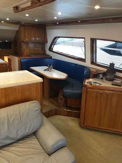 Quite Nice Yacht Photos Pics Interior of 2004 Bertram 570 Convertible yacht with wood cabinetry and blue seating.